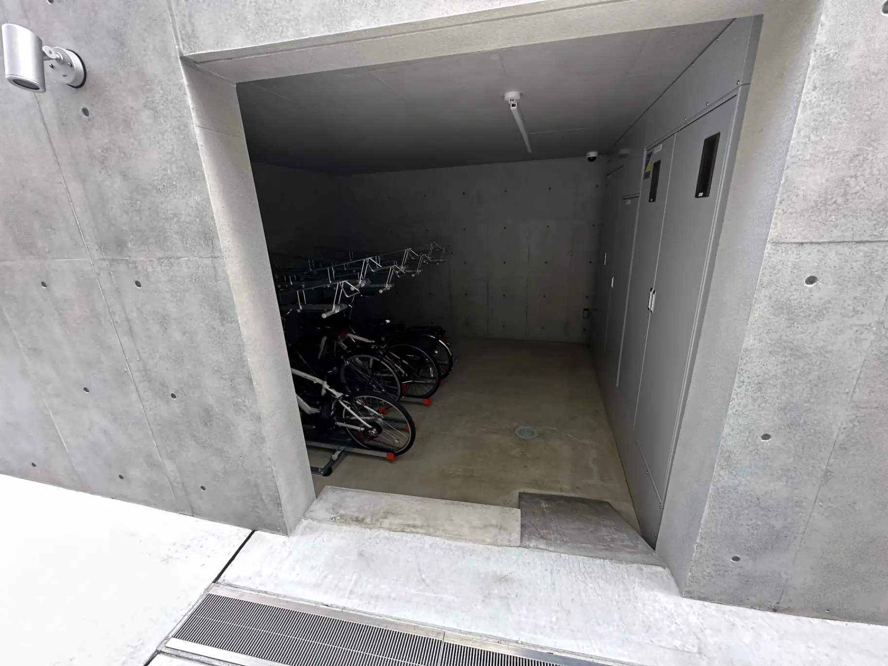 コンクリート打ちっぱなしの壁が特徴的な自転車駐輪スペース