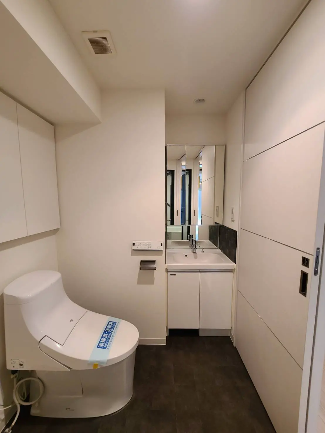 モダンなデザインのトイレと洗面台が設置された清潔なバスルーム