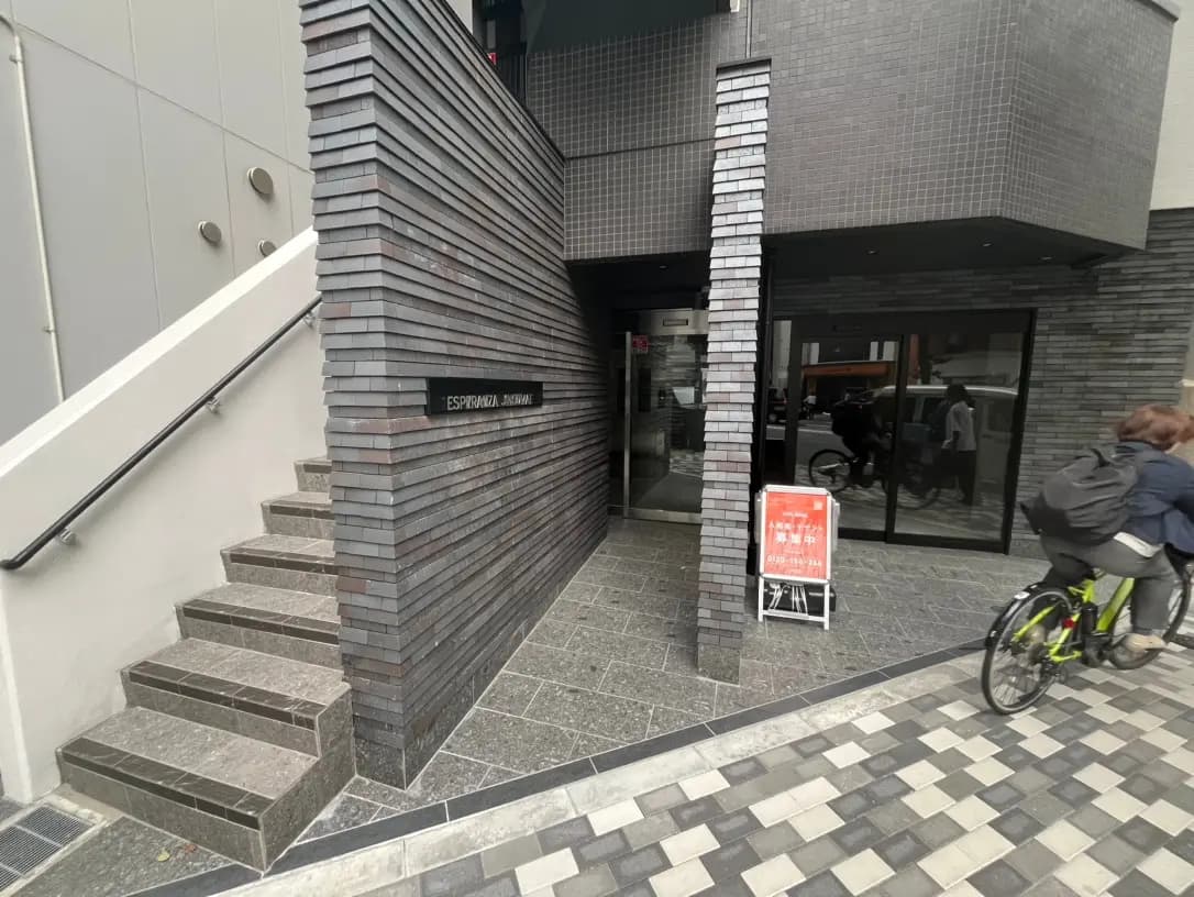 現代的な建築スタイルのビル入口、黒とグレーのタイル貼り、階段と手すり付き