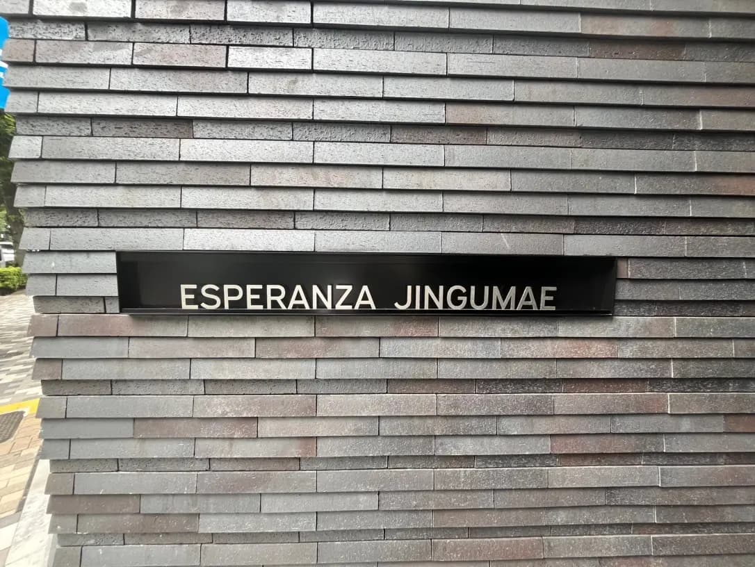 灰色のブロック壁に白い文字で「ESPERANZA JINGUMAE」と書かれた看板