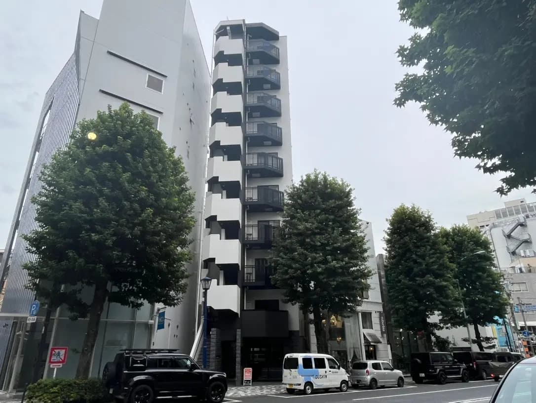 現代的な外観の都市型マンションと街路樹、曇り空の下の日本の都会風景