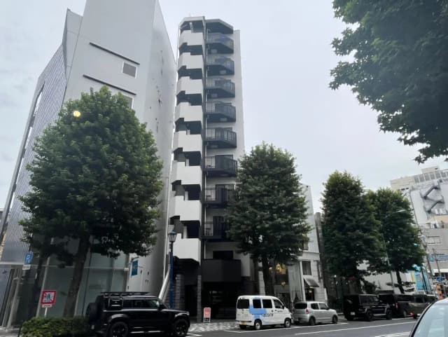 現代的な外観の都市型マンションと街路樹、曇り空の下の日本の都会風景