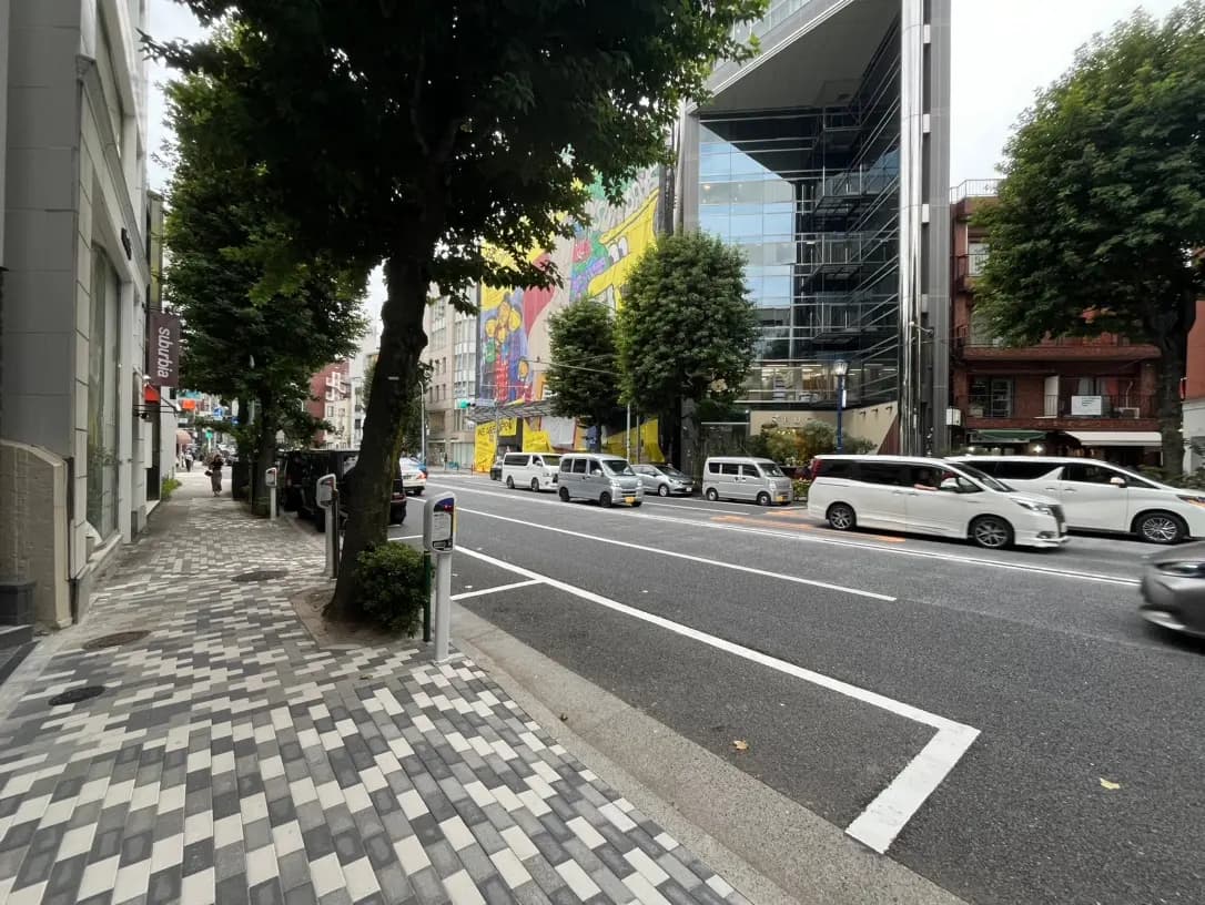市街地の歩道と道路、現代的なビルと街路樹、活気ある通りの風景