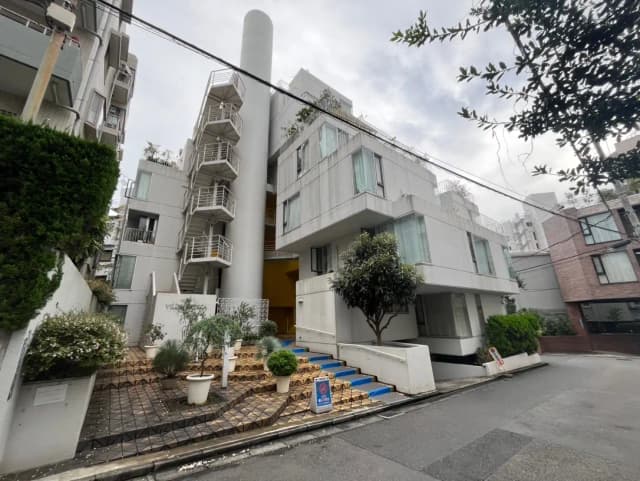 現代的なデザインのアパート建築、外階段と白い外壁が特徴の住宅街