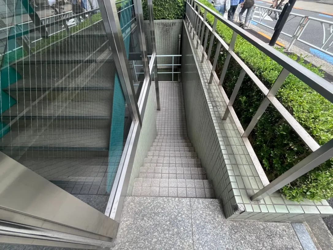 ガラスとスチールの手すりが特徴的な都市の屋外階段、緑の植栽に囲まれた歩道