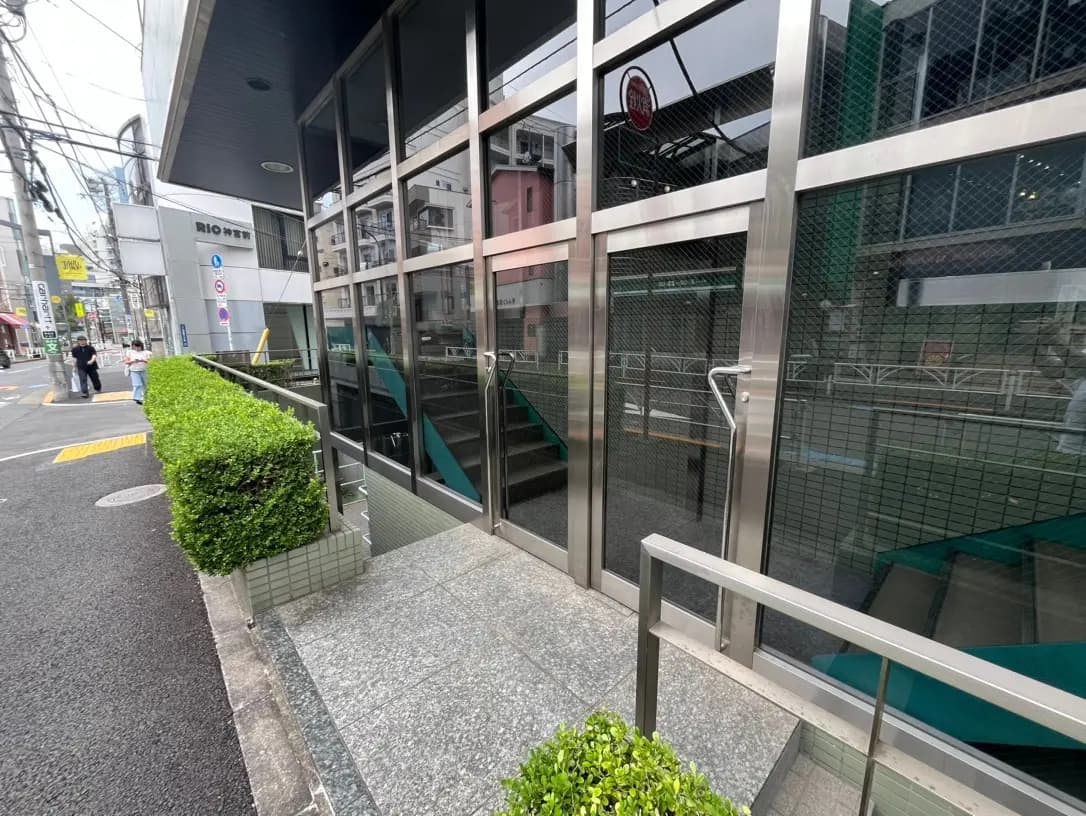 都会のオフィスビル入口、ガラスとスチールのデザイン、人通りの見える歩道