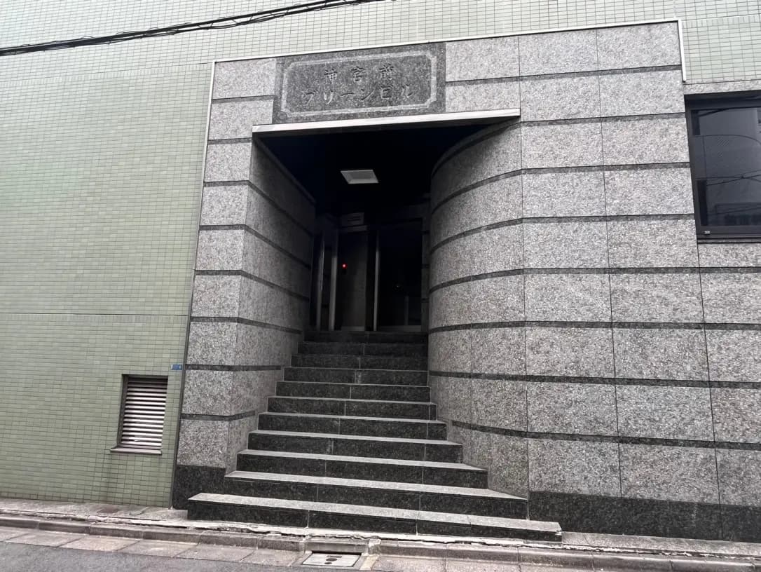 都会的な建物の石造りの入り口と階段、外壁にタイル装飾