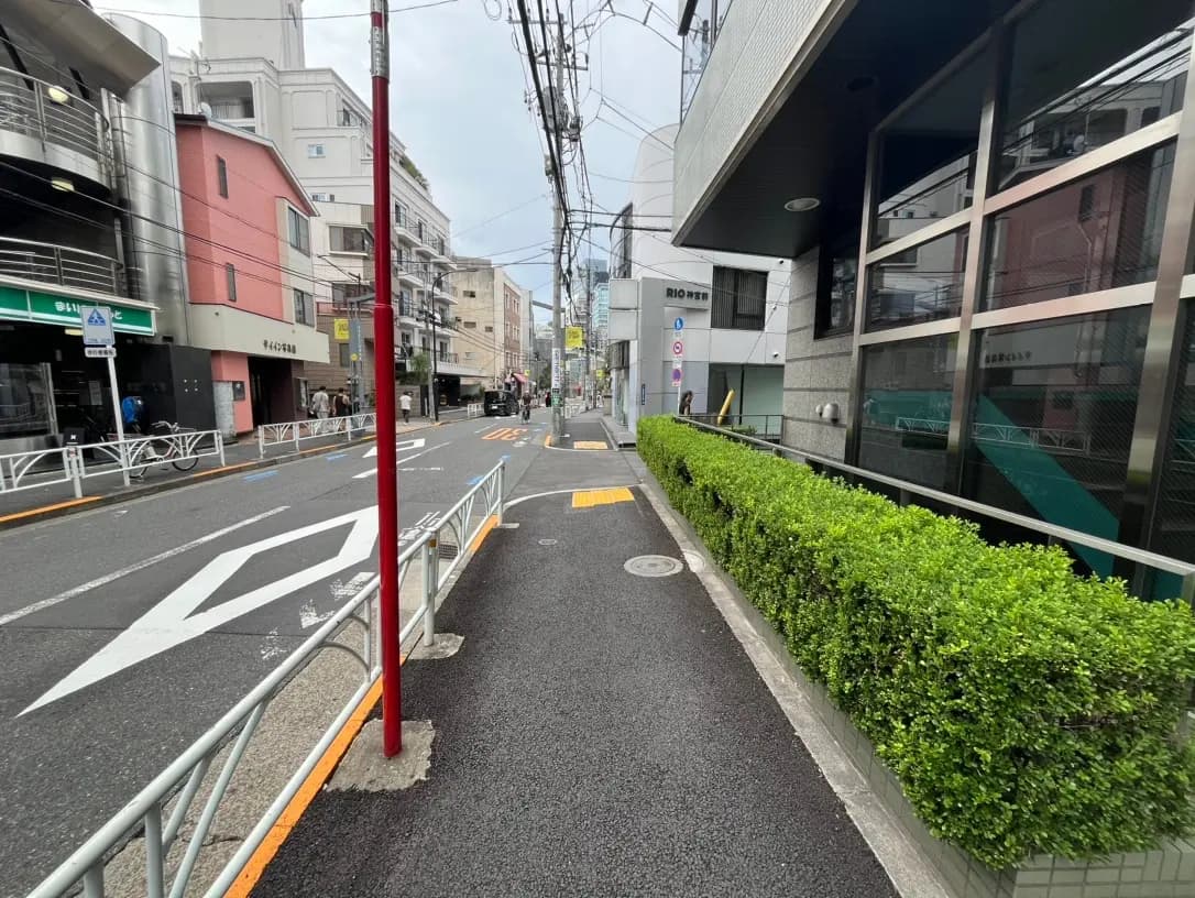 都市の交差点、歩道と自転車レーン、緑の植栽と都市の建物