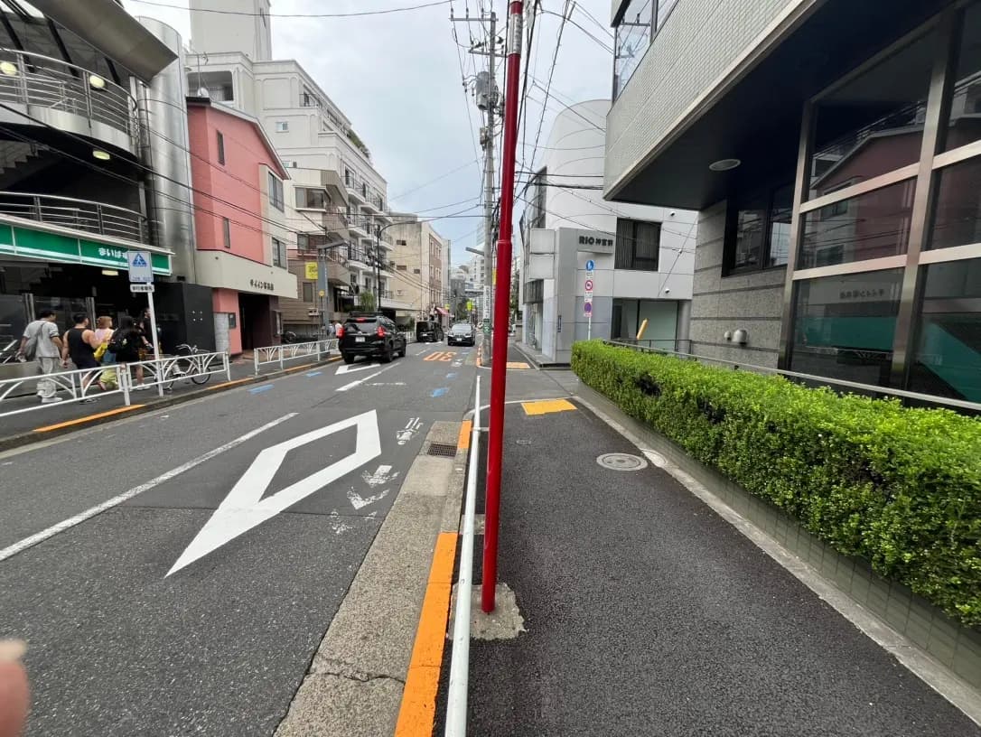 日本の都市部の道路と周囲の建物、自転車専用レーンと車の通行レーンが明示されたアスファルト舗装