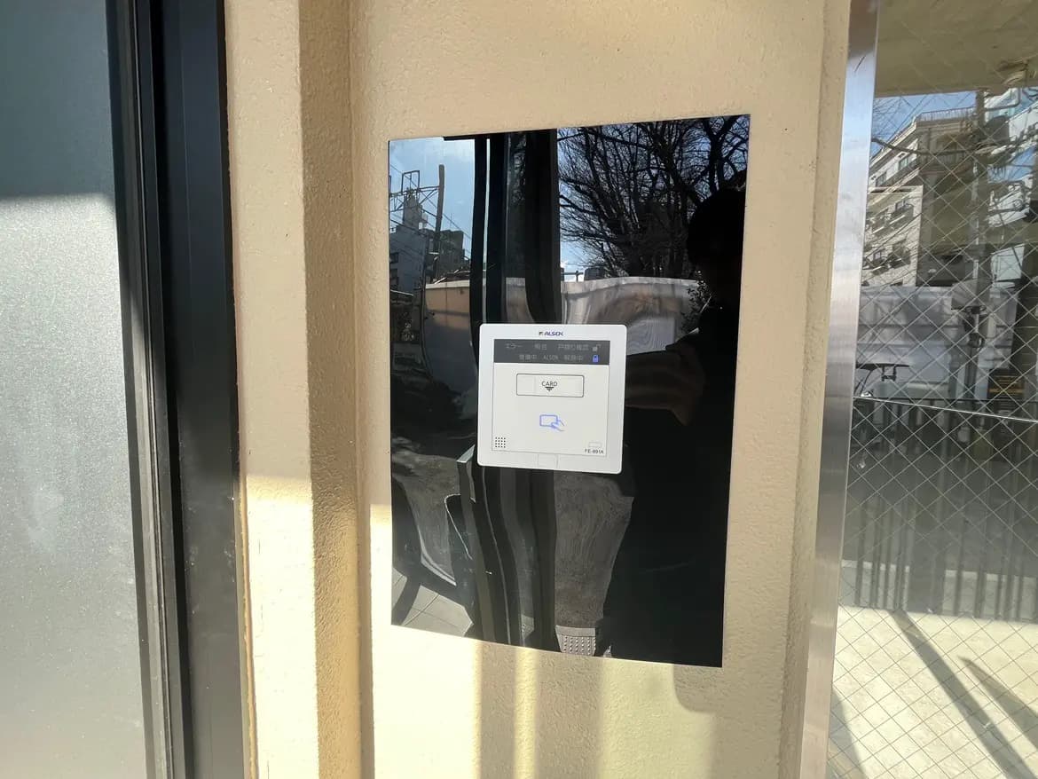 建物入口の顔認証セキュリティシステム、光沢のある黒い枠のガラスドアに設置
