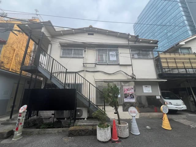 都市の中の伝統的な日本の家屋とモダンなビルが共存する街並み