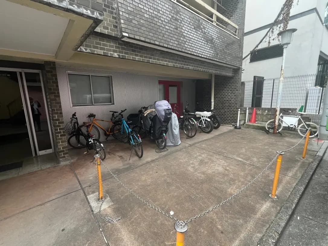 建物外観と駐輪場、自転車が並ぶアパートのエントランス