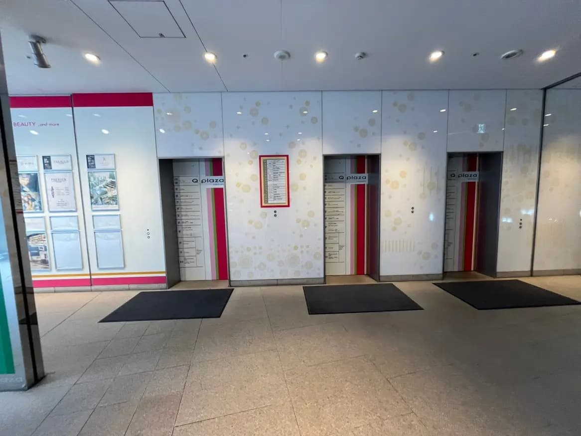 現代的なデザインのビル内エレベーターホール、案内板と花柄デザインの壁装飾