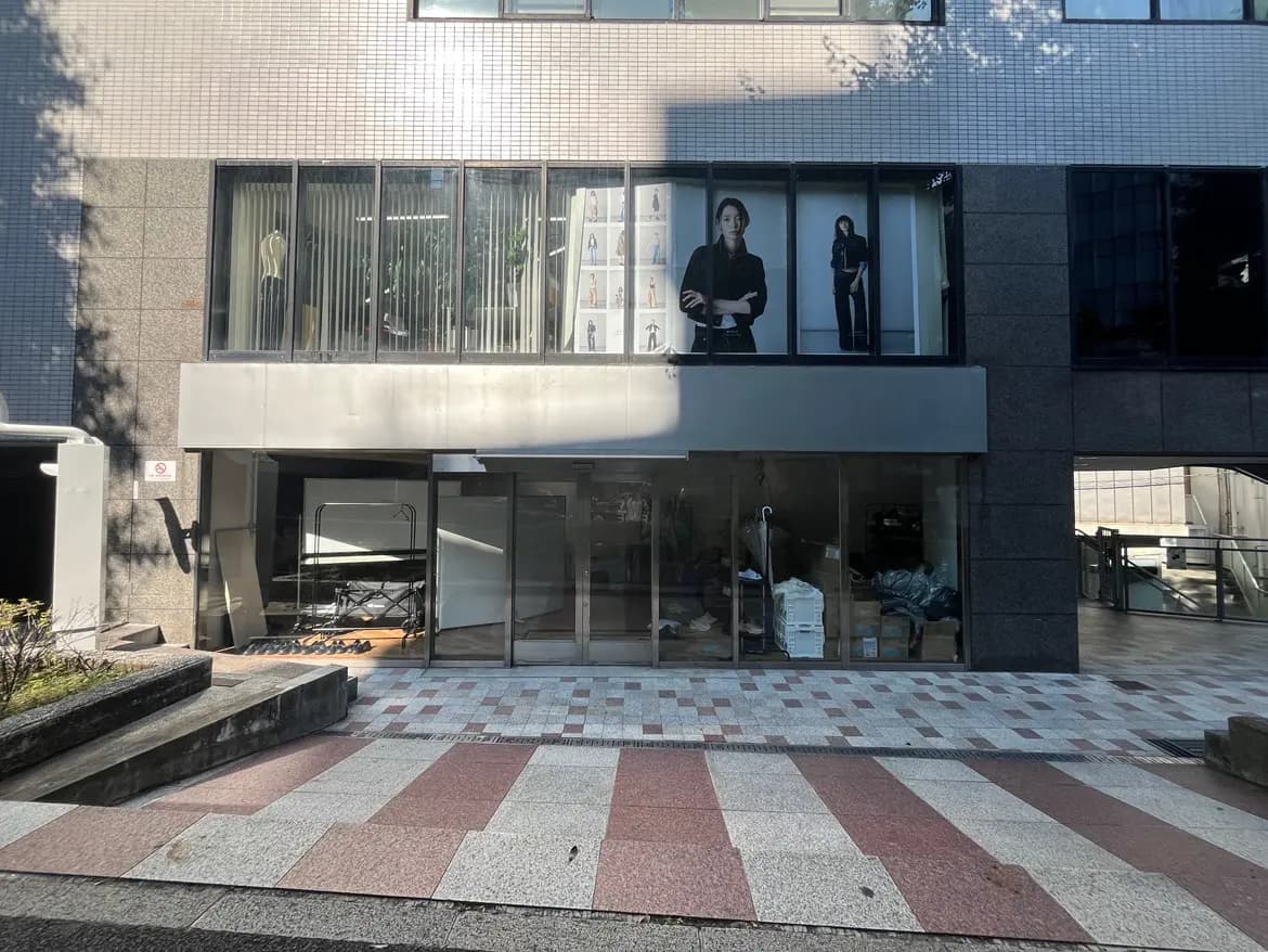 - 街中のファッション店舗の外観、ガラスのファサードと明るいディスプレイが印象的な商業ビルの一部