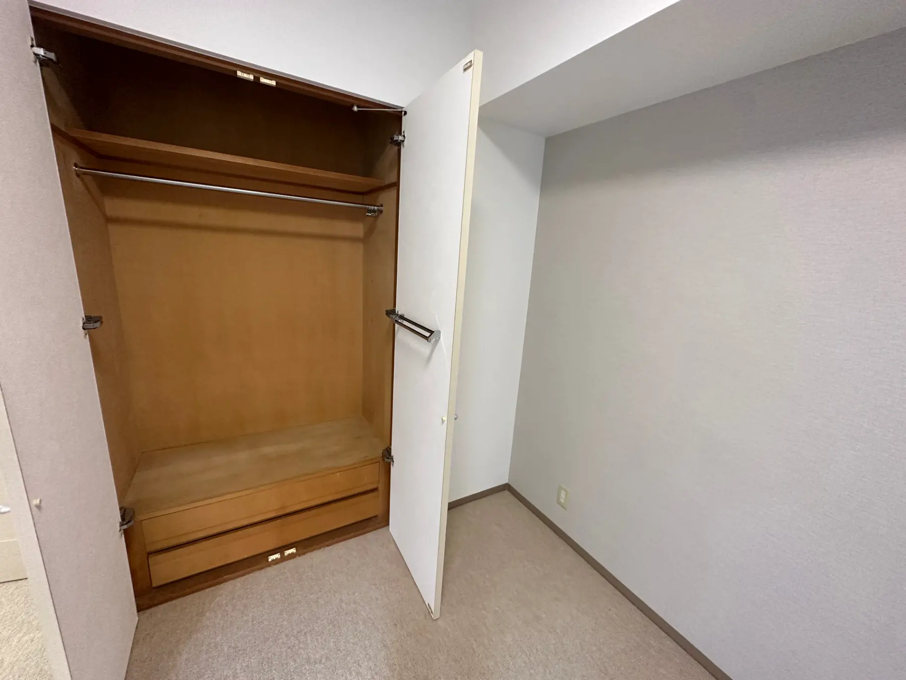 空のクローゼット、開いた扉と内蔵の棚、和室風の床と白い壁の部屋