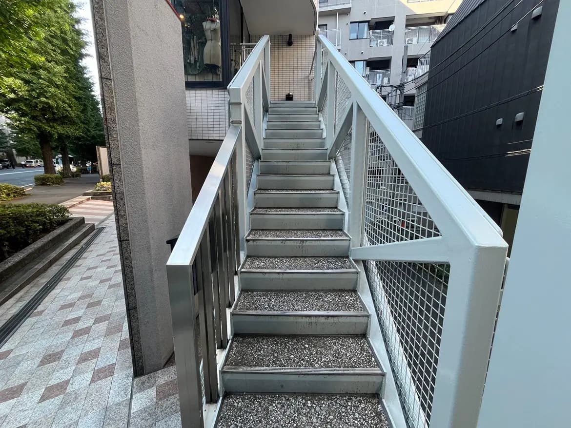 - アルミ製の手すり付き階段、周囲に植栽がある都市の風景、晴れた日中の屋外のアプローチ