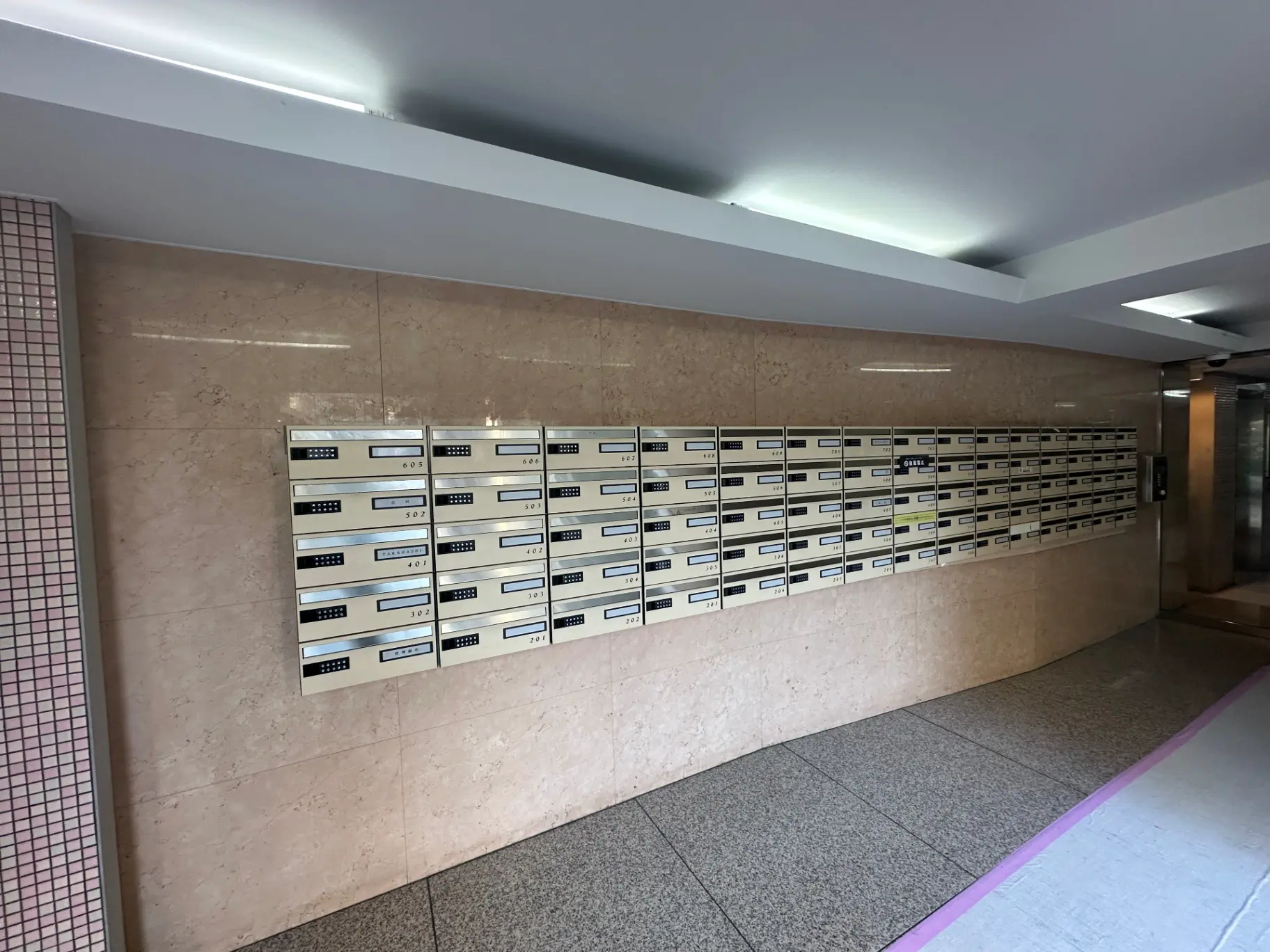 整然と並んだ郵便受けがあるマンションのエントランスホール