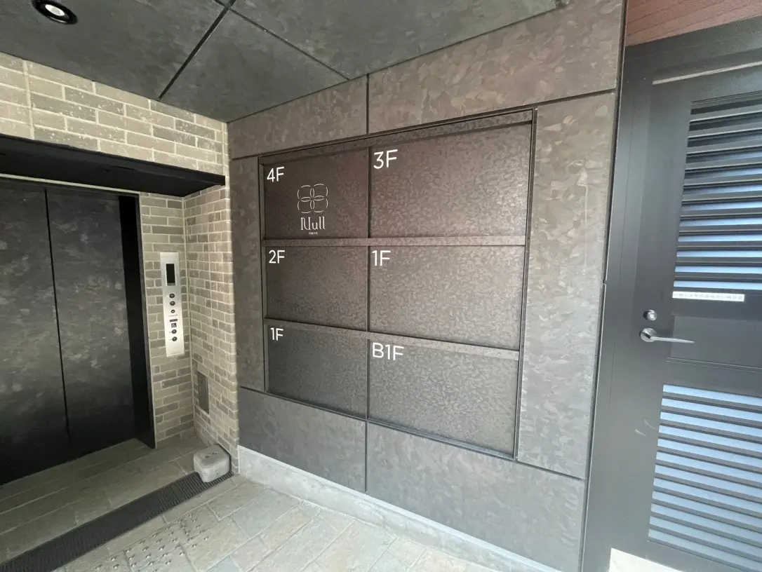 建物のエントランスにある案内板とインターホンが設置されたエントリーウェイ