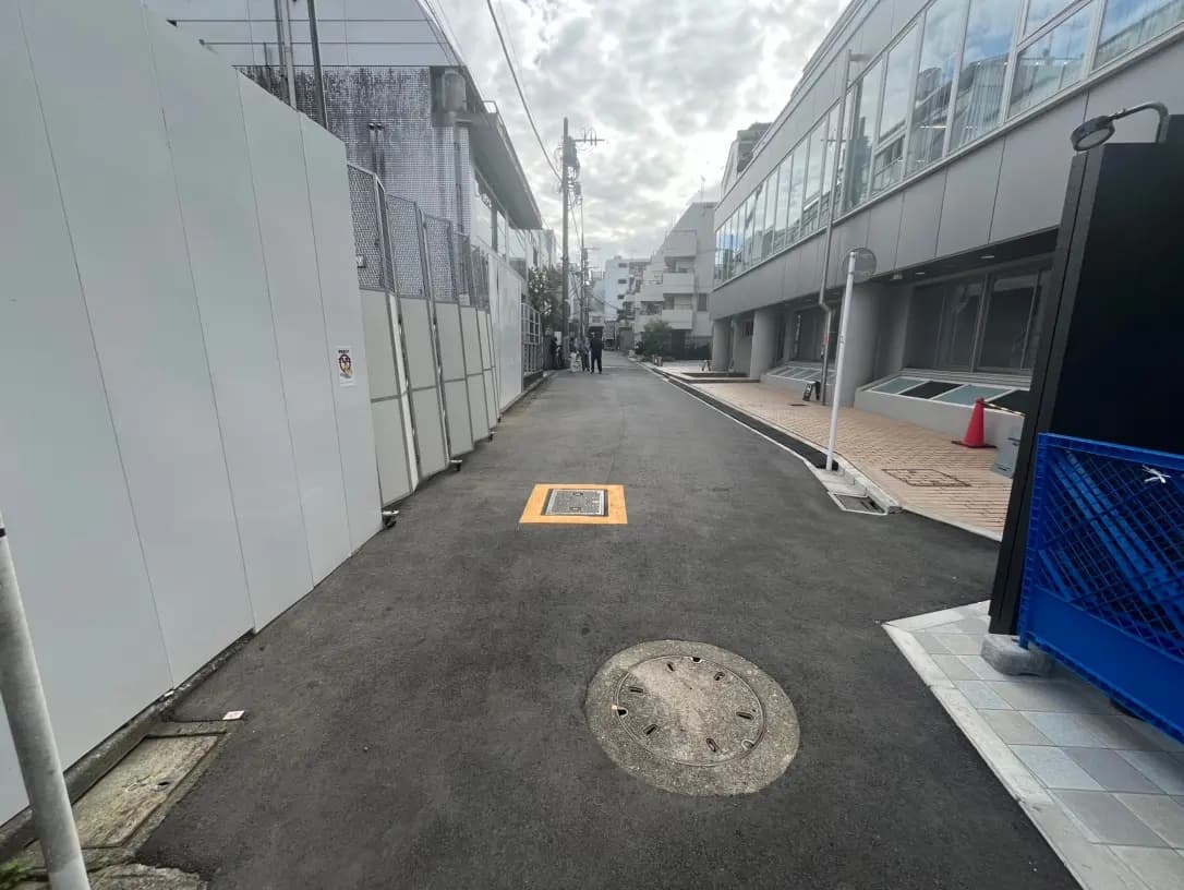 現代的な建物のある都市部の狭い路地、アスファルト舗装と明るい昼間の風景