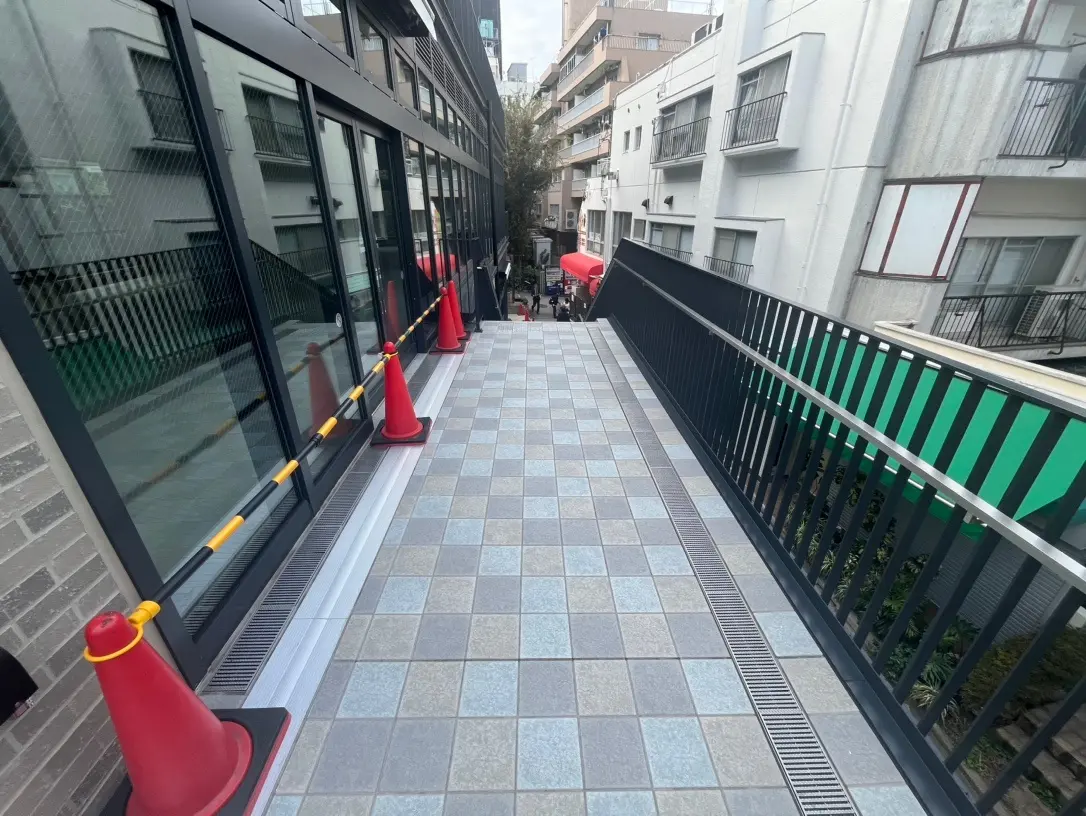 都会的なビルの屋外通路、タイル張りの床と防護のためのコーン配置