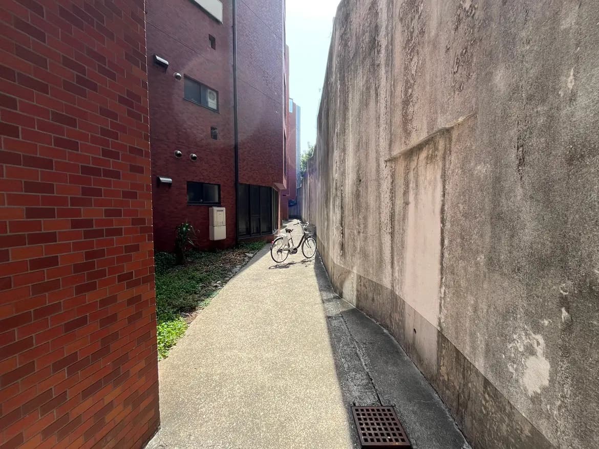 レンガ造りの壁が特徴的な都市の細い路地、駐輪された自転車が見える風景