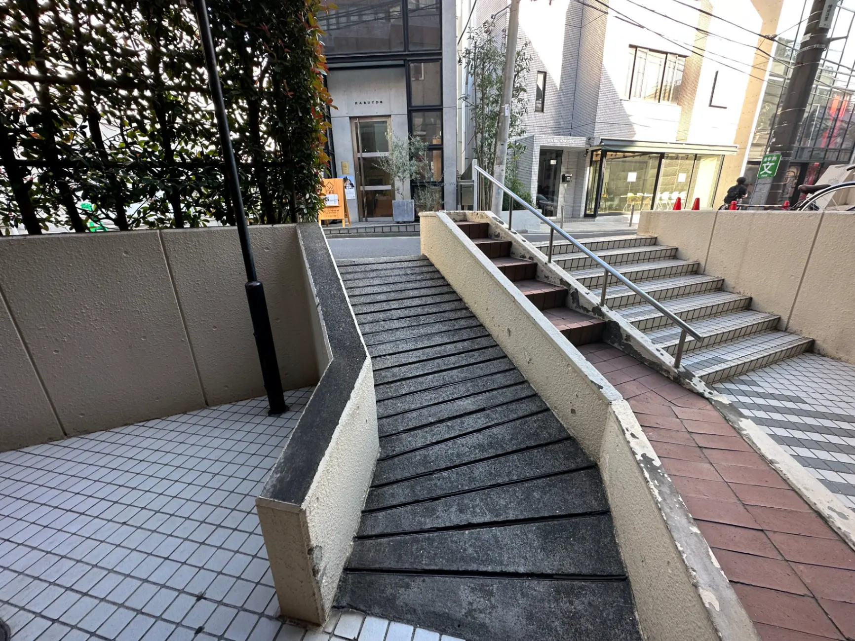 市街地にある車椅子対応のスロープと階段、手すり付き、日当たり良好な外観