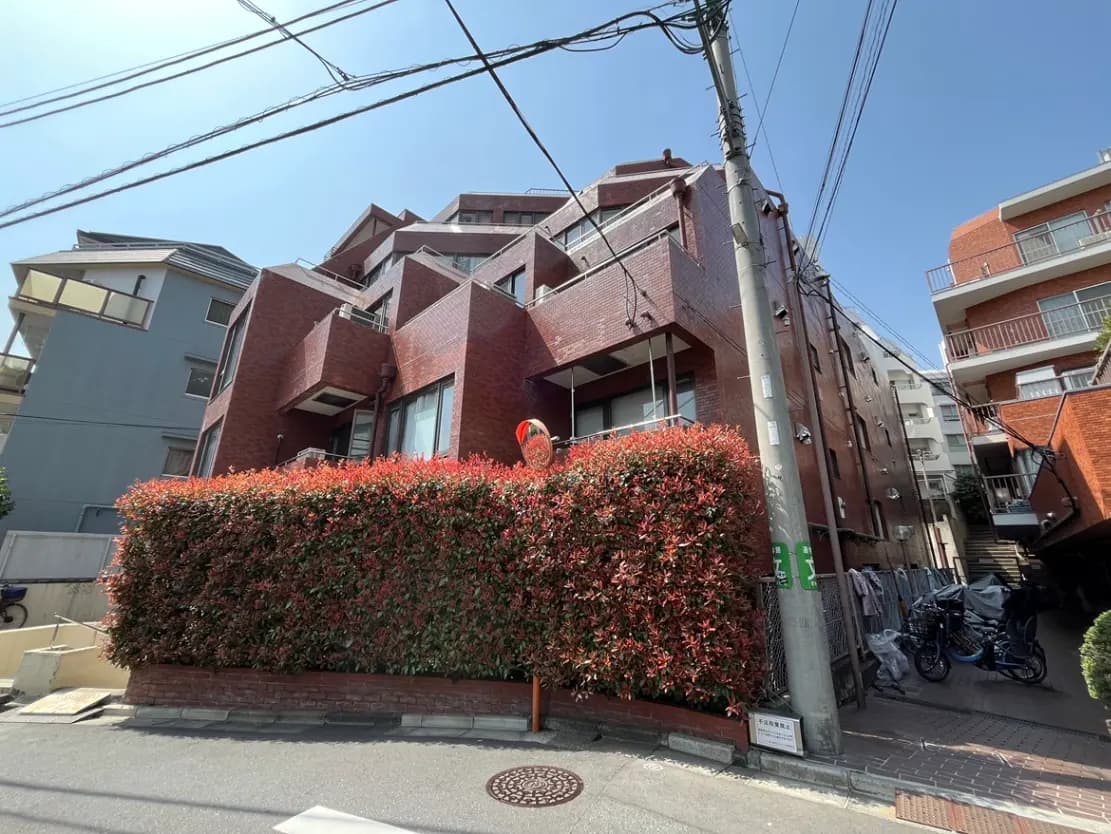 現代的なデザインの赤レンガ造りの建物、都会的な環境の中にあるアパートメント、日差しが明るい住宅街