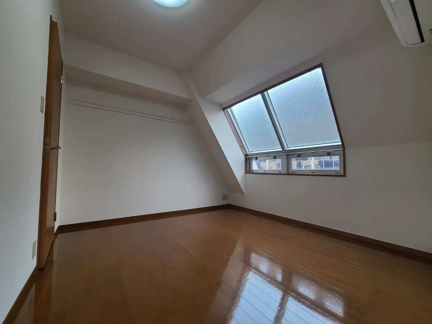 天窓と大きな窓が特徴的な明るい空間の居室