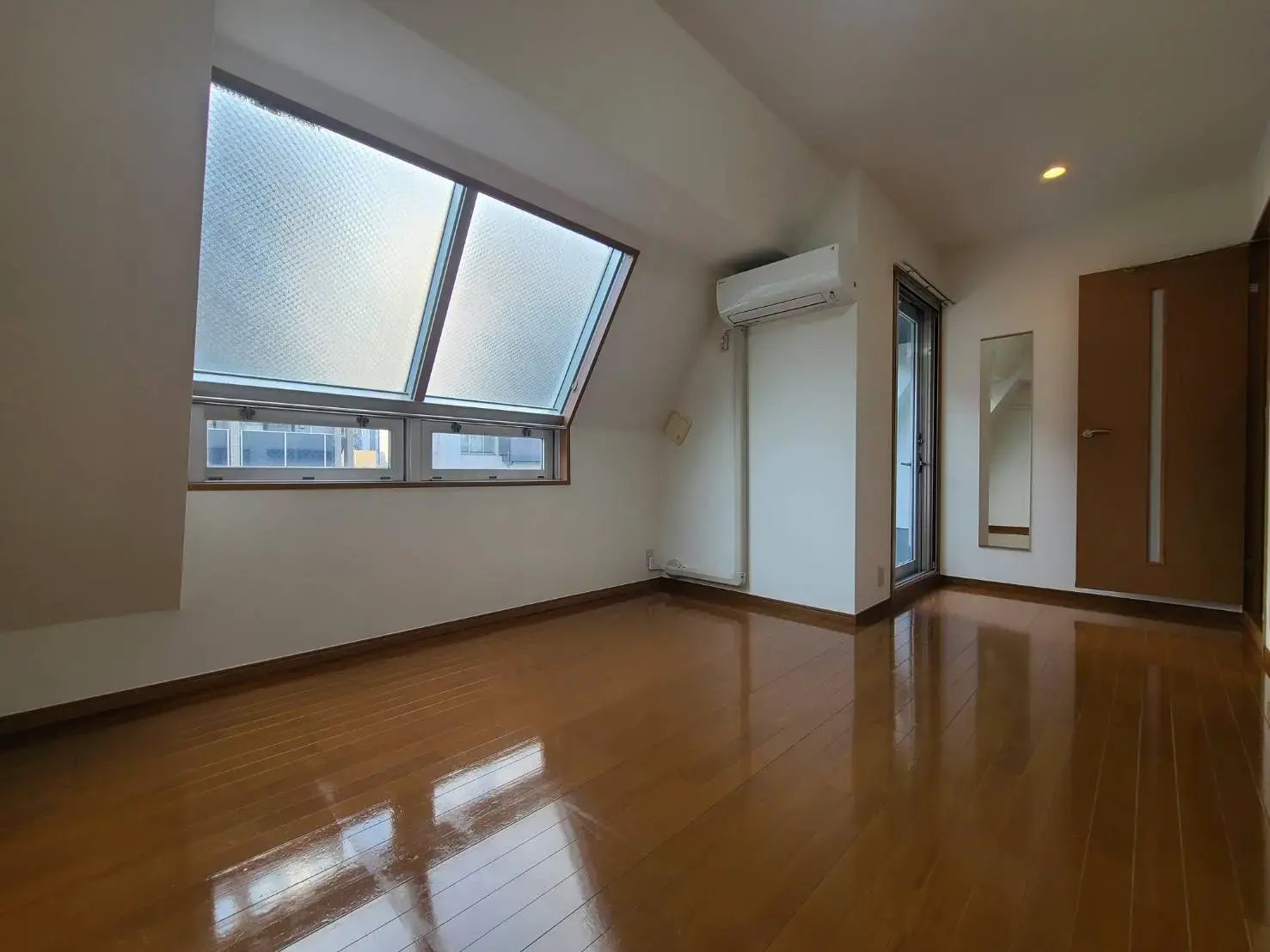 自然光がたっぷり入る明るいリビング、広々とした木目調のフローリング