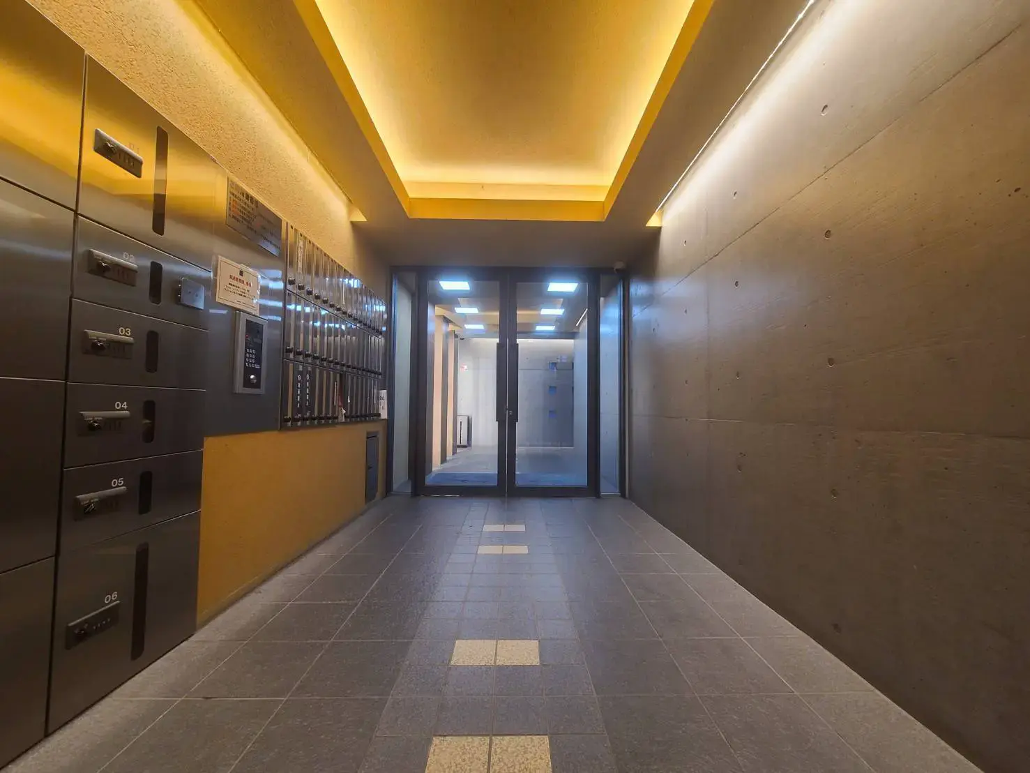 モダンな照明とコンクリート打ちっぱなしの壁が特徴のエントランスホール