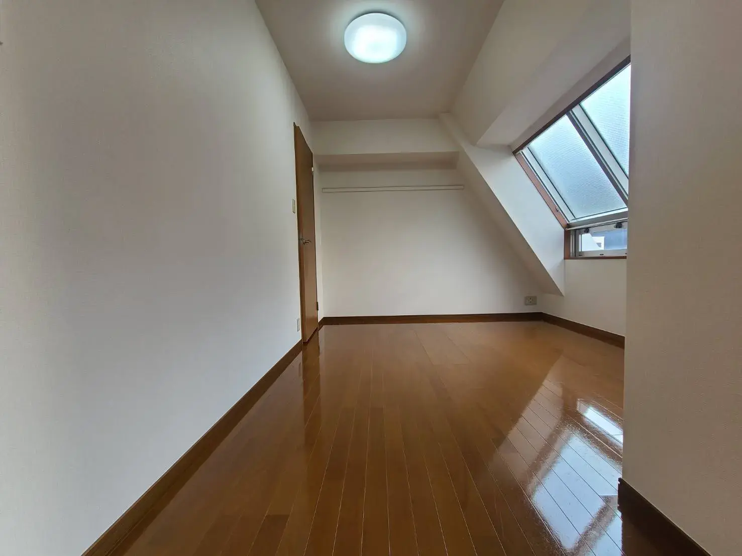 明るい採光を取り入れた屋根窓付きの洋室