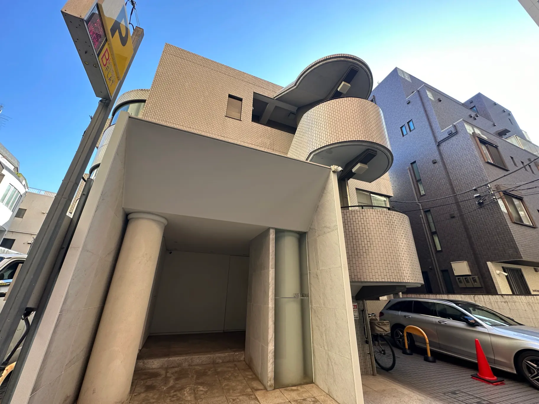 現代的なデザインの都市型建築物、円形の窓と柱のある入口