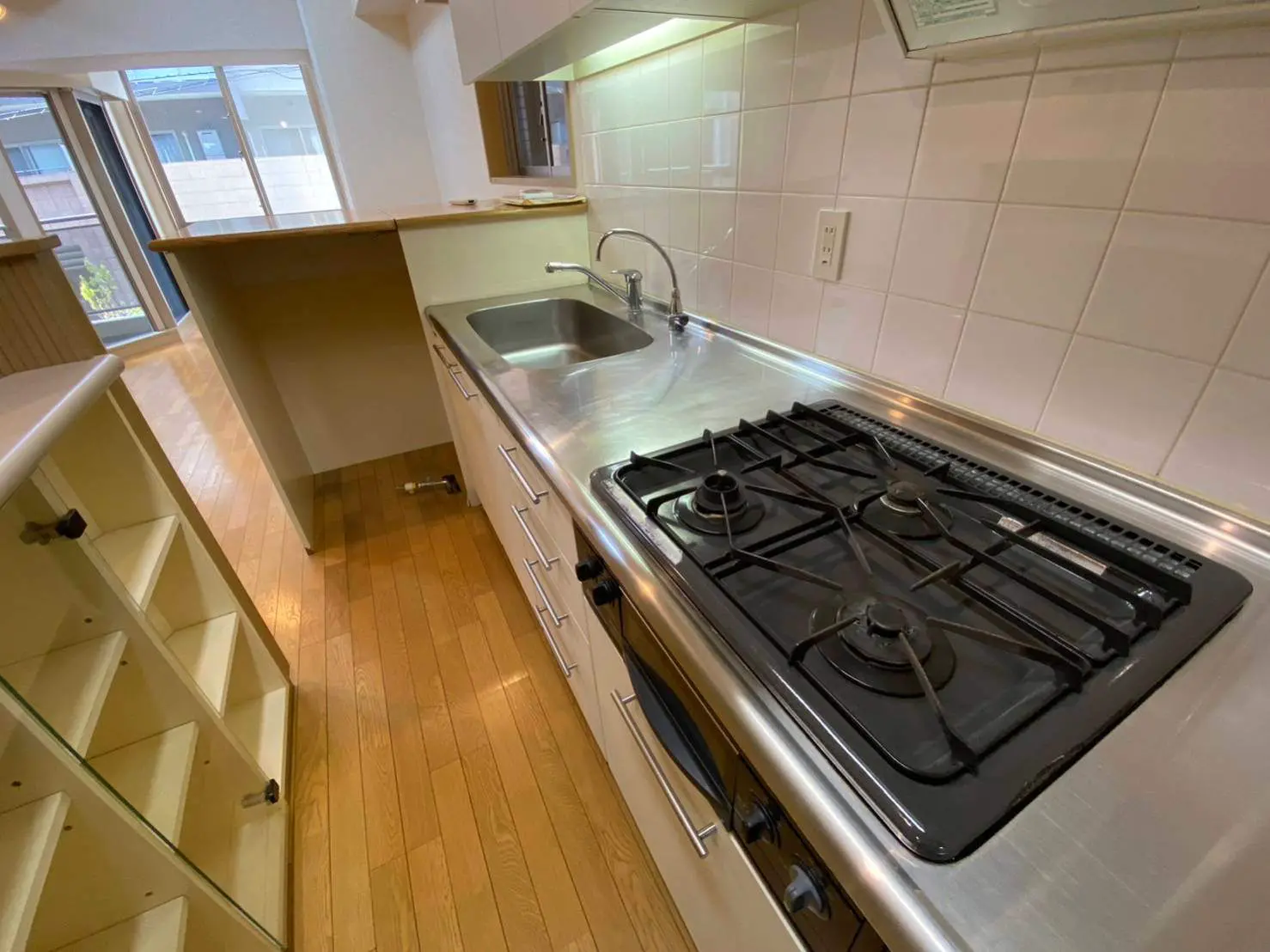 コンパクトなキッチンスペースと天然木フローリング、明るい窓付近