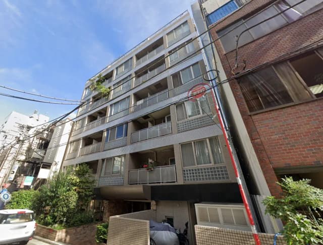 都市の日当たり良好なマンション外観、バルコニー付きの住宅建築、青空と街並み