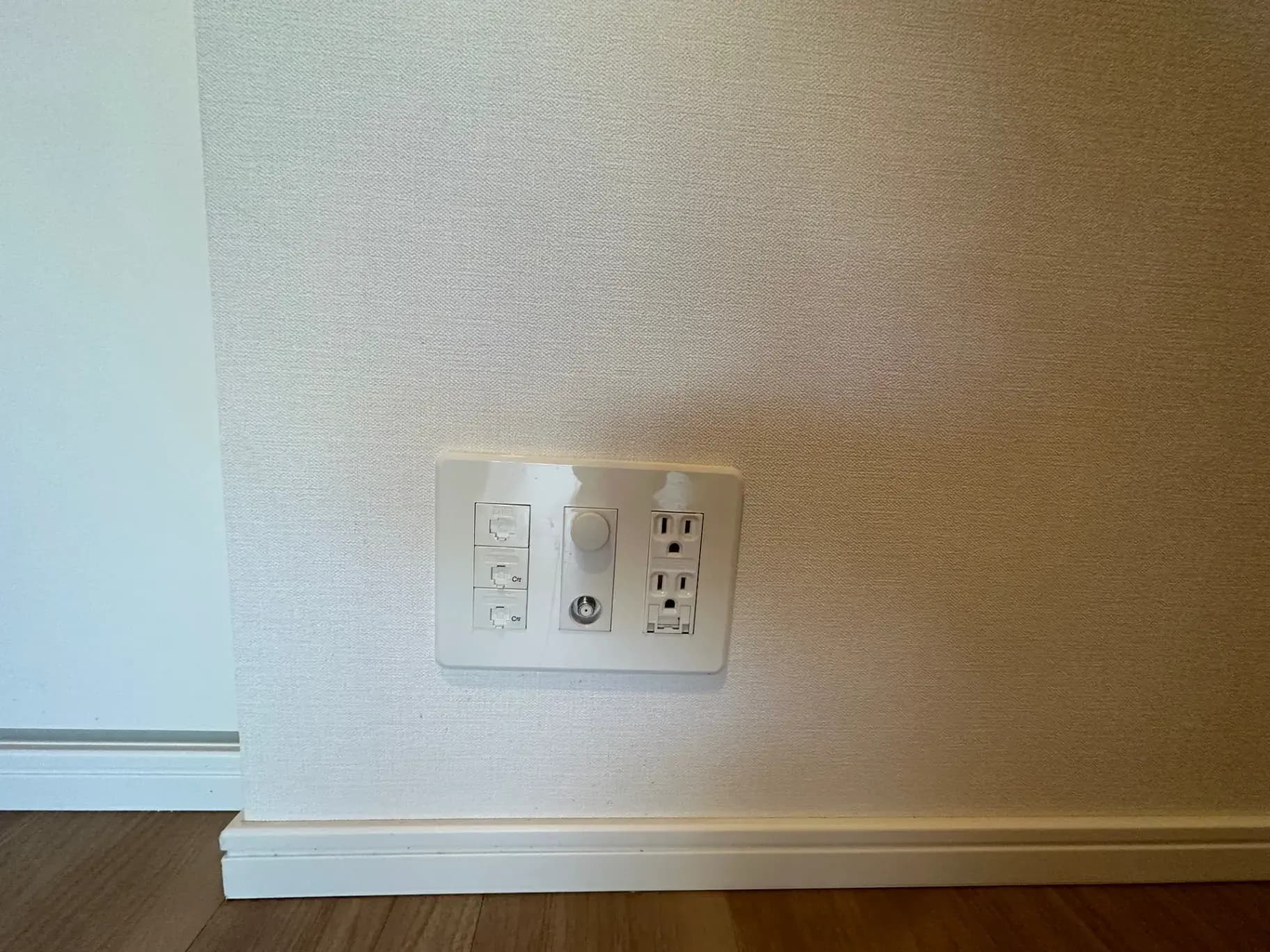 壁に取り付けられたコンセントとスイッチがあるシンプルな室内の壁