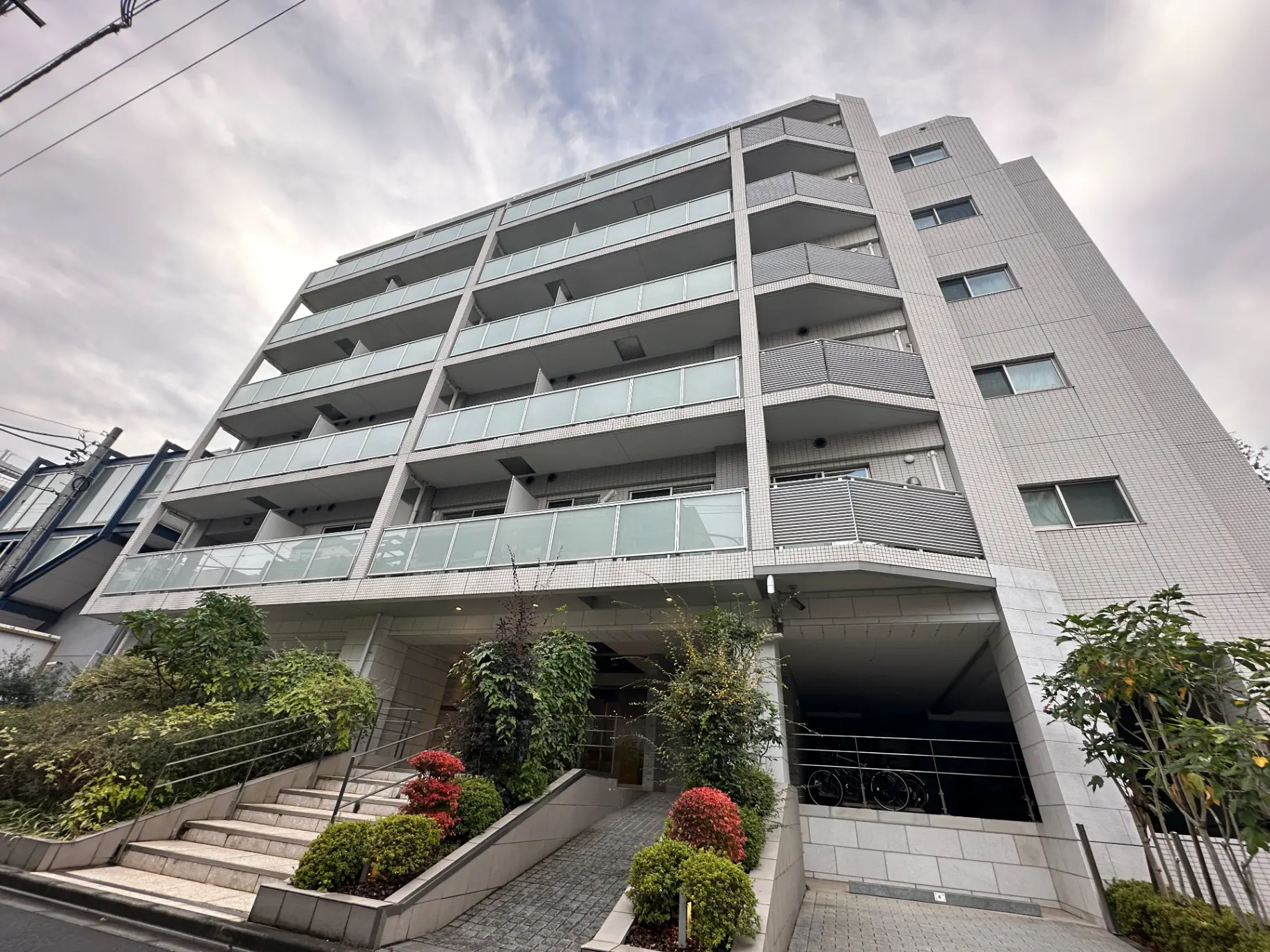 都市型のモダンな外観を持つマンション、ゆったりとしたエントランスアプローチ