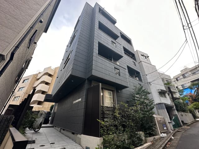 ダークトーンのタイル張りが特徴的なモダンなビルの外観
