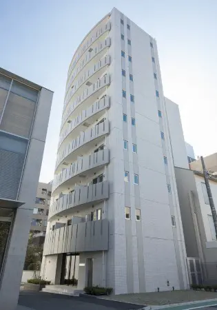 - 近代的なデザインの白いマンション、丸みを帯びた外観とバルコニー付きの複数階建ての建物、周囲の都市景観