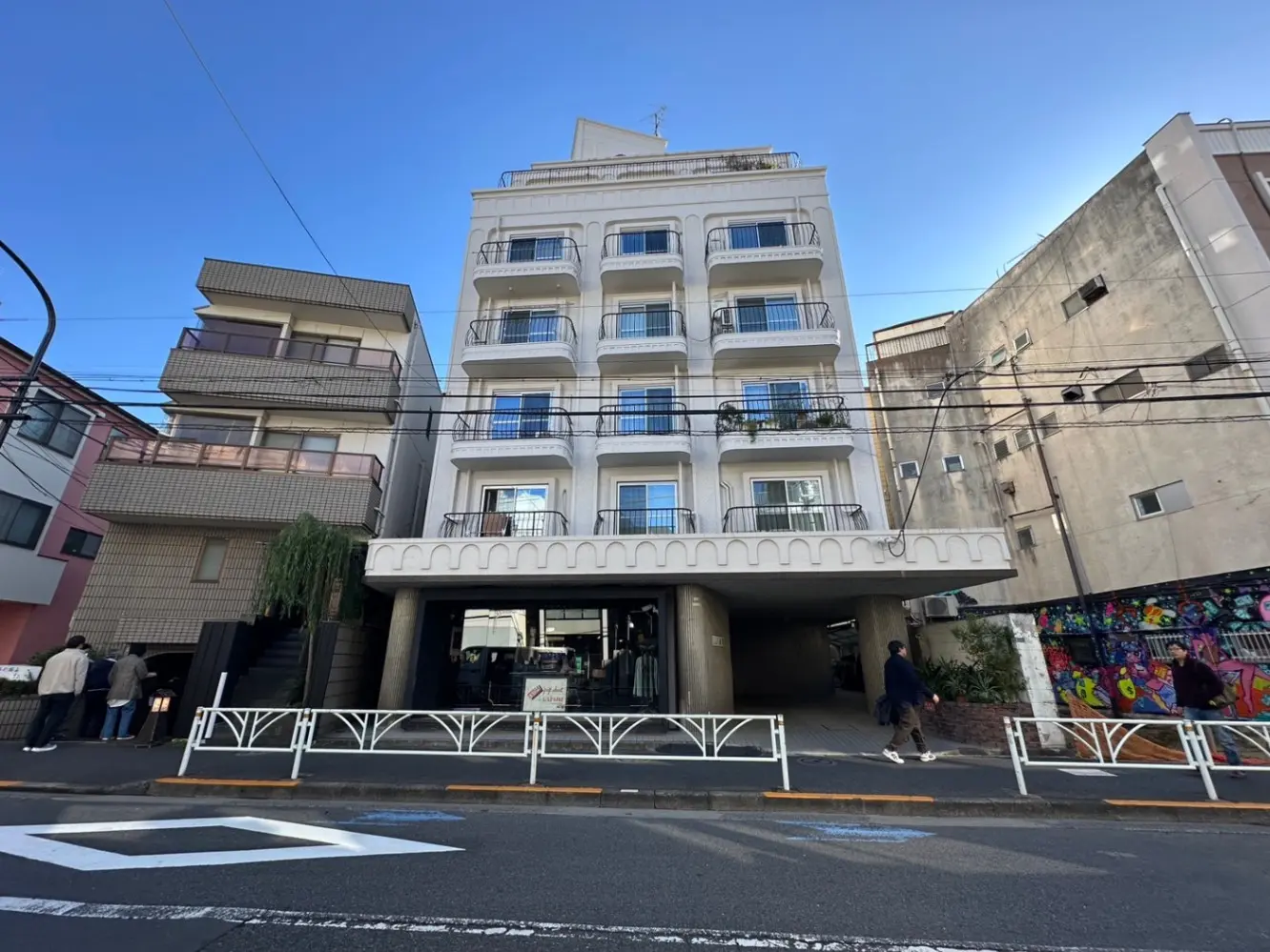 日本の都市部にある現代的なマンションビル、アーチ型の入口とバルコニー付きのファサード
