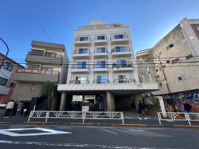 日本の都市部にある現代的なマンションビル、アーチ型の入口とバルコニー付きのファサード