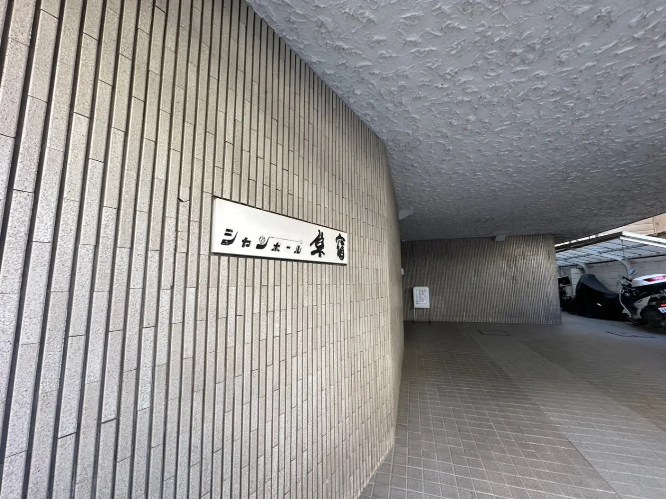 駐車場入り口の看板、都市の建物のアーチ状の通路とタイル張りの壁