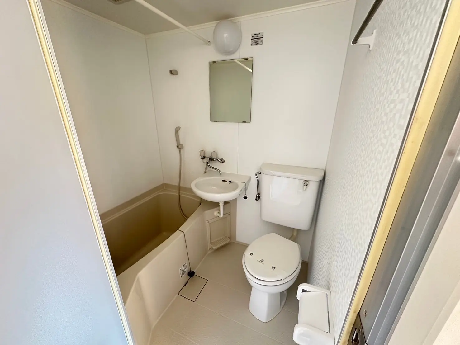 シンプルなデザインの白いバスルーム、バスタブと洗面台、トイレが設置された清潔感のあるインテリア