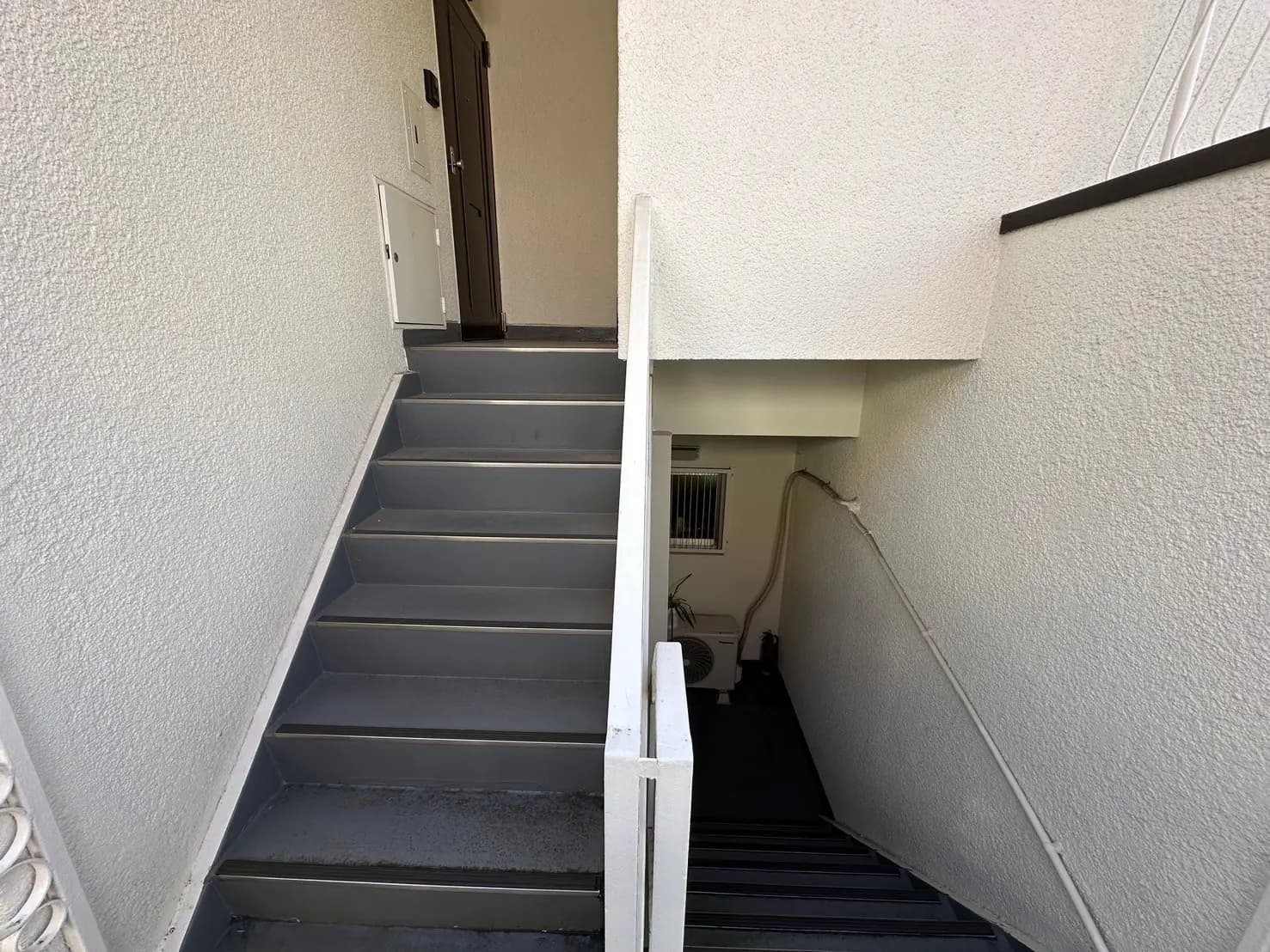 建物の外階段と入り口、グレーの階段が特徴的な室外デザイン