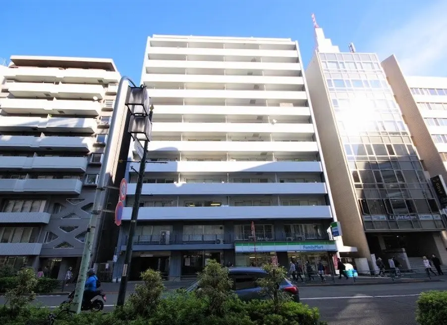日差しが差し込む都市の風景、多層ビルと商業施設、コンビニエンスストア「ファミリーマート」が見える街角