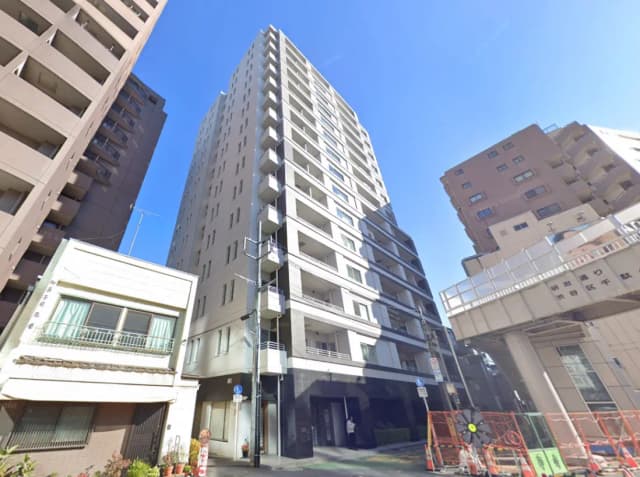 - 高層ビルと周囲の建物、青空をバックにした都市風景の景観