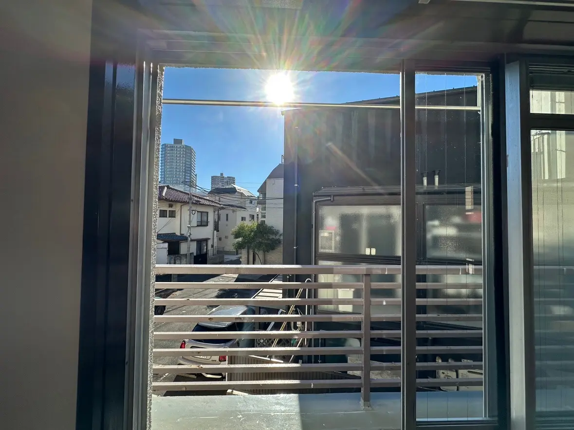 バルコニーと都市の景色、朝の日差しが差し込む窓ガラス