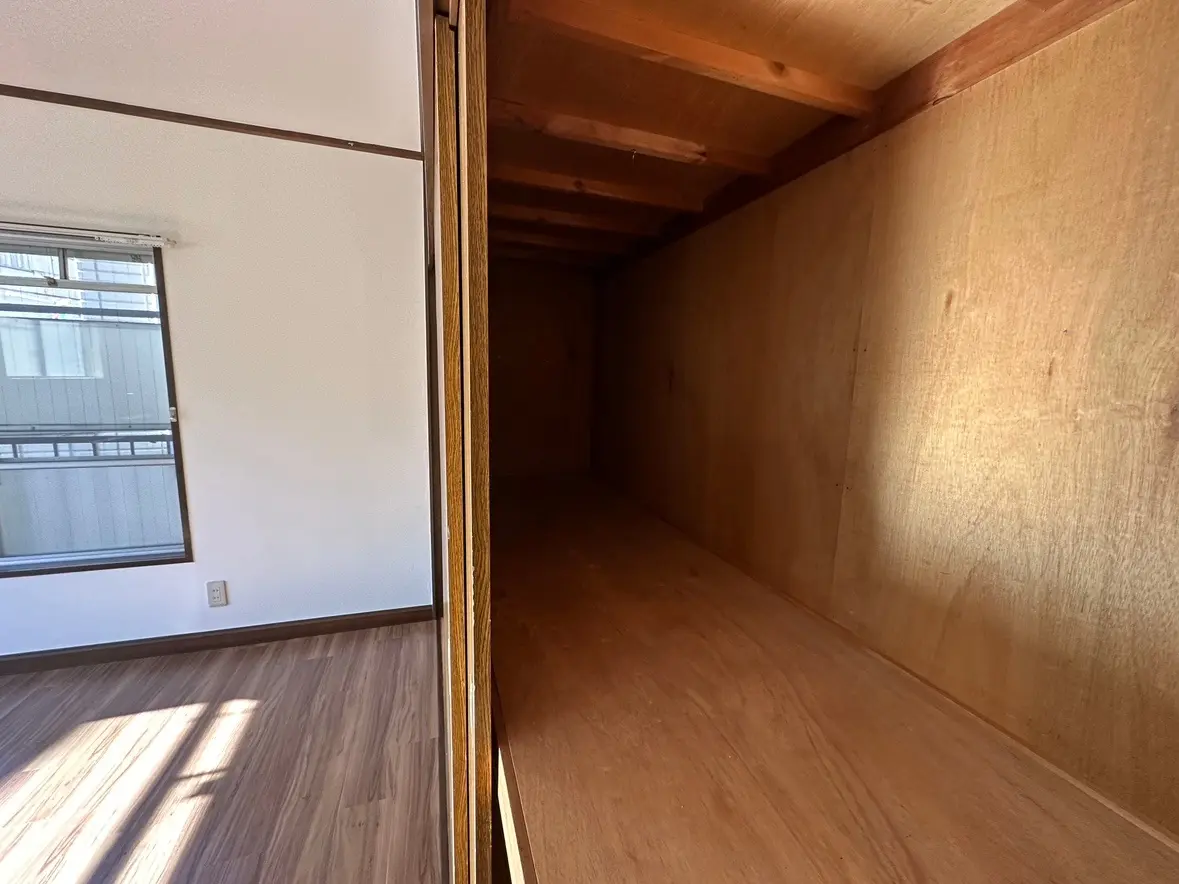 明るい自然光が差し込む空間、クローゼットの内部と洋室の一角、無垢材のフロアと白い壁のインテリア