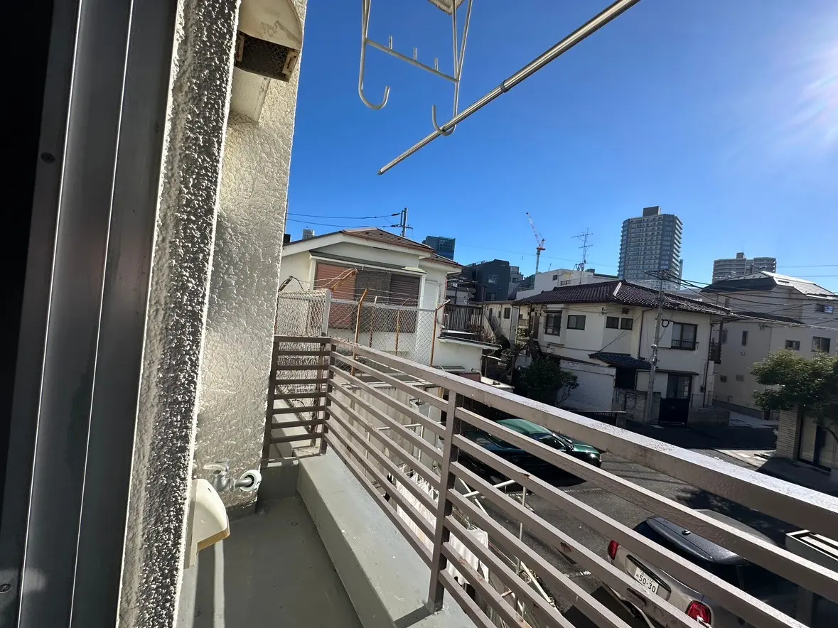 晴れた日の住宅街のベランダからの眺め、洗濯物を干すためのハンガー、多層住宅と青空