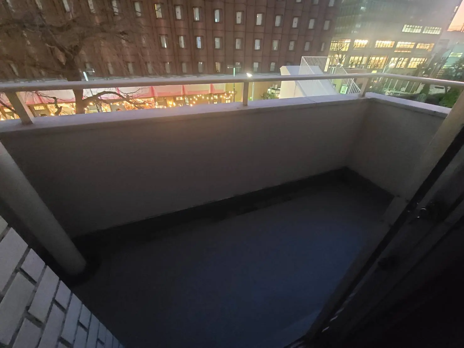 夕暮れ時のバルコニーの景色、都市の明かりが見える住宅街