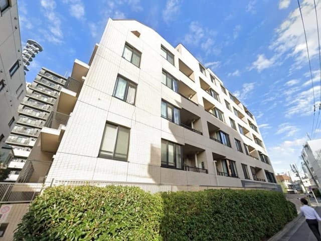 現代的なマンションの外観、白壁とバルコニーが特徴的な住宅街の建物